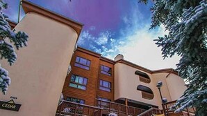 Un hotel de varios pisos con fachada color beige, balcones y un letrero que dice "CEDAR".
