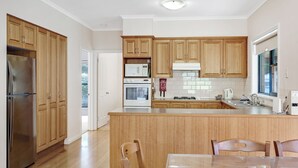Une cuisine moderne avec des meubles en bois, des appareils en acier inoxydable et un îlot central.