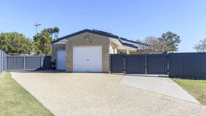 Een gebouw met twee verdiepingen, een garage en een overdekte oprit.