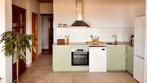 A modern kitchen with a built-in oven, dishwasher, and a welcome sign above the entrance. - Beautiful rural house with swimming pool and sea views, special discounts (Algarrobo)