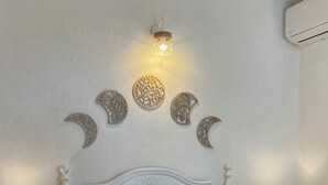 A neatly made bed with white bedding, two bedside tables with lamps, and decorative wall art above the bed. - Beautiful rural house with swimming pool and sea views, special discounts (Algarrobo)