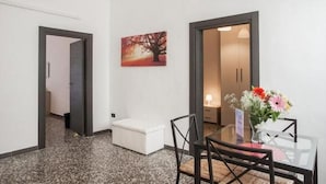 Ein Hotelzimmer mit Essbereich, einem Bild an der Wand und einer Blumenvase.