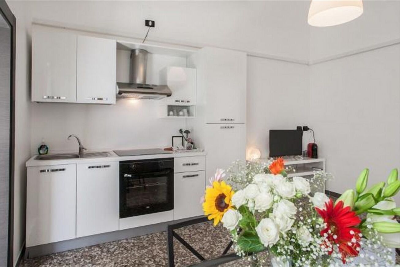 A modern kitchen with white cabinetry, a built-in oven, and a gas stove.