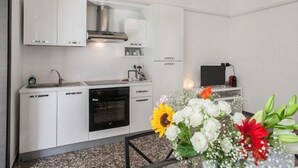 Eine moderne Küche mit weißen Schränken, einem Einbauofen und einem Gasherd.