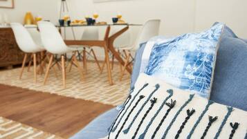Ein modernes Wohnzimmer mit einer Couch, einem Kissen mit Muster und einem Essbereich mit Stühlen und einem Tisch.