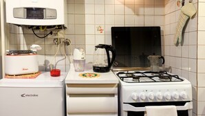 A kitchen with a stove, a coffee maker, a toaster, and a water dispenser.