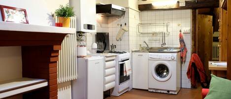 Een koelkast, een oven, een kookplaat, een eettafel