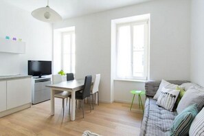A modern living space with a dining area, a sofa, and a television. - GuestHost - Beautiful and spacious 76 sqm apartment located in a strategic position just a short distance from Piazza Oberdan, Porto Vecchio, Palazzo Gopcevich and Piazza Unita d'Italia. The particular position of the house allows to reach easily the his (Trieste)