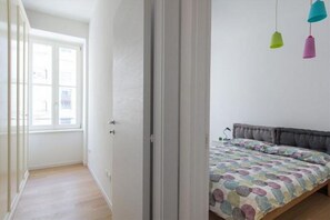 Un dormitorio con cama, ventana y puerta.