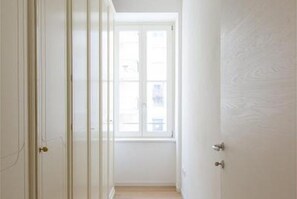 A narrow hallway with a door leading to a room with a window. - GuestHost - Beautiful and spacious 76 sqm apartment located in a strategic position just a short distance from Piazza Oberdan, Porto Vecchio, Palazzo Gopcevich and Piazza Unita d'Italia. The particular position of the house allows to reach easily the his (Trieste)