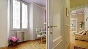 A room with a dining table and chairs, a radiator, and a potted plant. - The elegance in the heart of Florence (Firenze)