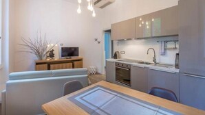 Eine moderne Küche mit Essbereich, inklusive Tisch, Stühle und einer Couch.