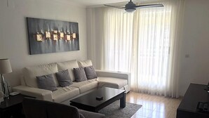 A modern living room with a sofa, coffee table, and a black armchair.
