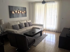 Uma sala de estar moderna com um sofá, uma mesa de centro e uma poltrona preta.