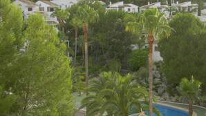 Un quartiere residenziale con case bianche, palme e una piscina.