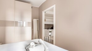 Una habitación de hotel con cama, armario y vistas al área de la cocina.