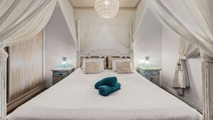 A bedroom with a large bed, white curtains, a chandelier, and two bedside tables with lamps. - House with heated swimming pool, solarium, large garden, high-speed WIFI access. (Lajares)