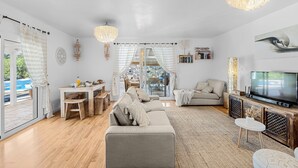A modern living room with a sofa, TV, and dining area. - House with heated swimming pool, solarium, large garden, high-speed WIFI access. (Lajares)