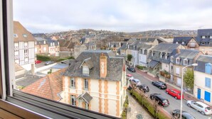 A view of a residential street with houses, cars, and a distant townscape. - Nice apartment for 2 people with WIFI and TV (Trouville-sur-mer)