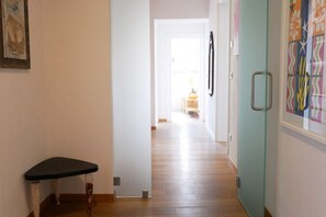 Ein Flur mit einer Bank, einer Tür mit Griff und einer Wand mit buntem Muster.