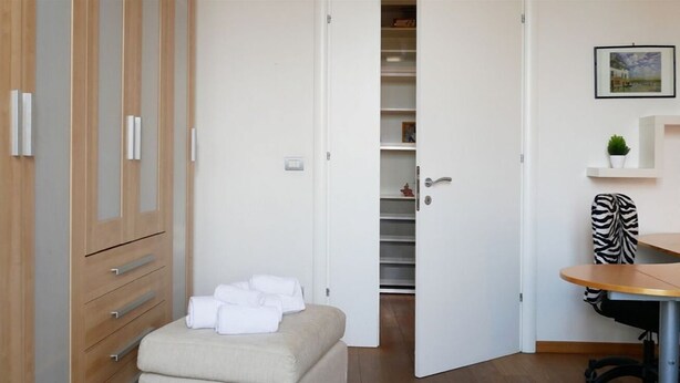 Una camera da letto con un letto, un armadio, una scrivania e una sedia.