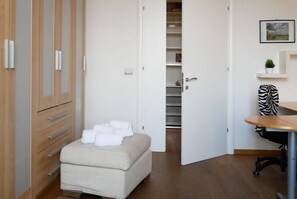 Ein Schlafzimmer mit Bett, Kleiderschrank, Schreibtisch und Stuhl.
