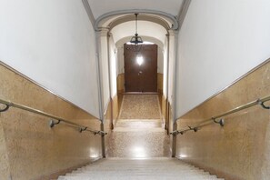Eine Marmortreppe mit Geländern, die zu einer Tür oben führt.