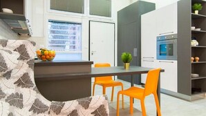 A modern kitchen with a dining area, including a sofa, chairs, and a table.