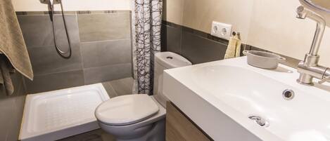 Une salle de bain moderne équipée d’une baignoire, de toilettes et d’un lavabo.