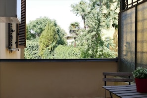 A balcony with a view of trees and a building.