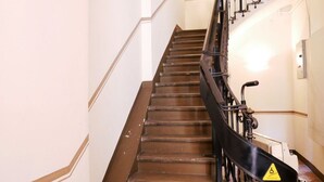 Un escalier muni d’une rampe et d’un panneau d’avertissement.