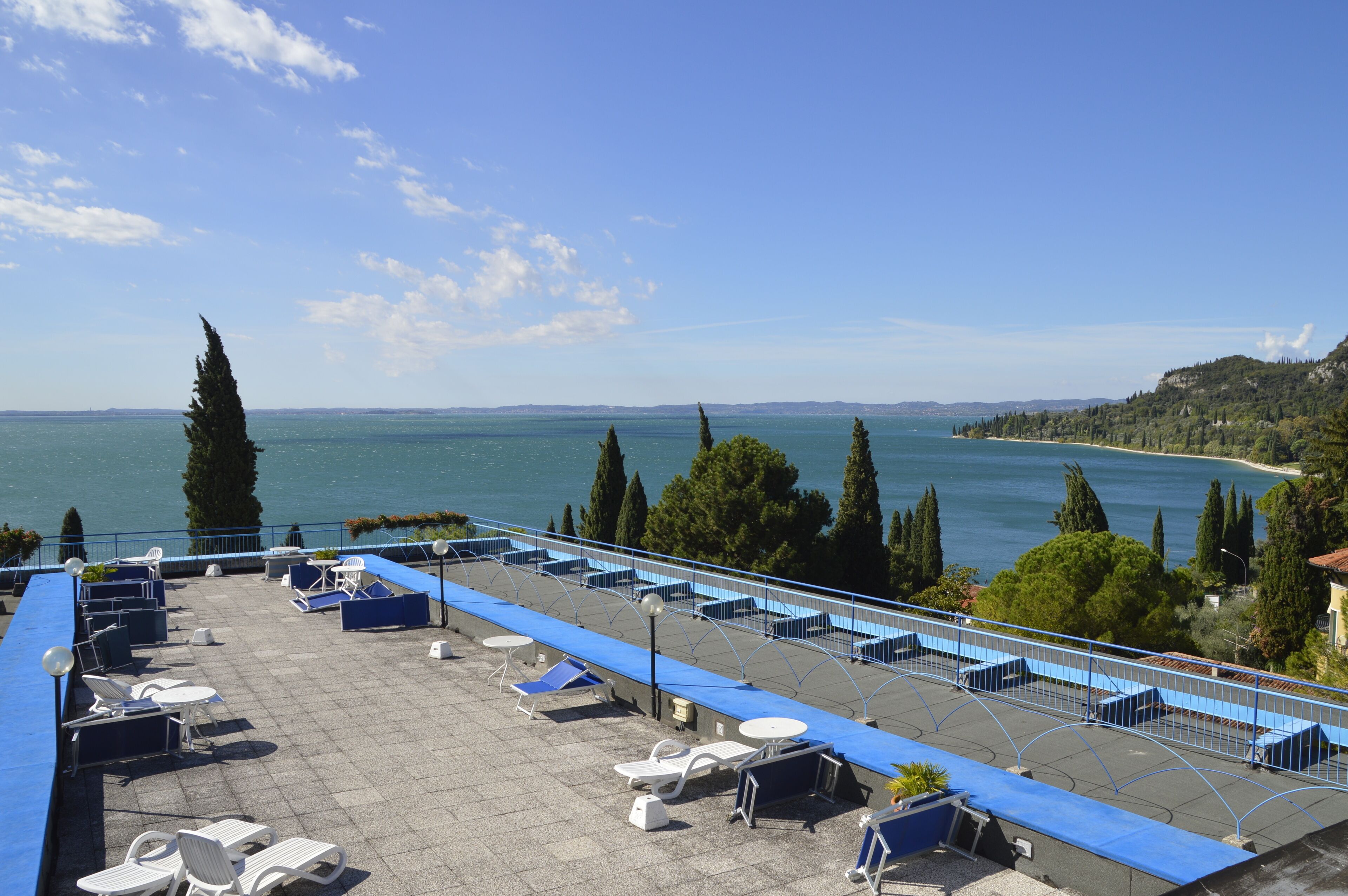 A rooftop terrace with outdoor seating and a view of the sea.