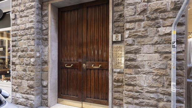 A stone building with a wooden double door, a number plaque, and a metal pole. - GuestHost - Cozy two-room apartment - Piazza della Signoria! NEW (Firenze)