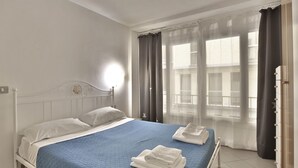 A bedroom with a bed, curtains, and a window. - GuestHost - Cozy two-room apartment - Piazza della Signoria! NEW (Firenze)