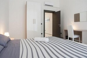 Une chambre d’hôtel comprenant un lit, un bureau, une chaise et une armoire.
