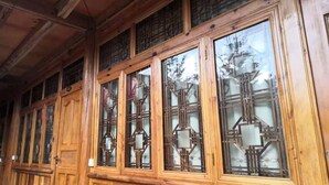 Un intérieur en bois agrémenté de grandes fenêtres dotées de montures métalliques complexes et de vitres dépolies.