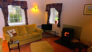 A cozy living room with a sofa, a television, and a fireplace. - Escape to Rural Highlands Stunning Scenery, Sound of the Burn  Licence PK11943F (Aberfeldy)