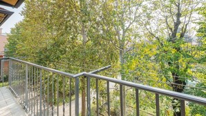 A balcony with a metal railing overlooking a garden with trees and shrubs. - GuestHost - Large, bright and well-kept apartment on the third floor of a building near the Maggiore Hospital. The historic center is easily accessible by public transport.The apartment, ideal for 5 people, is fully equipped and has 24h WiFi, A / C and h (Bologna)