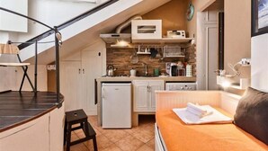 Cocina compacta con refrigerador, microondas y estufa.