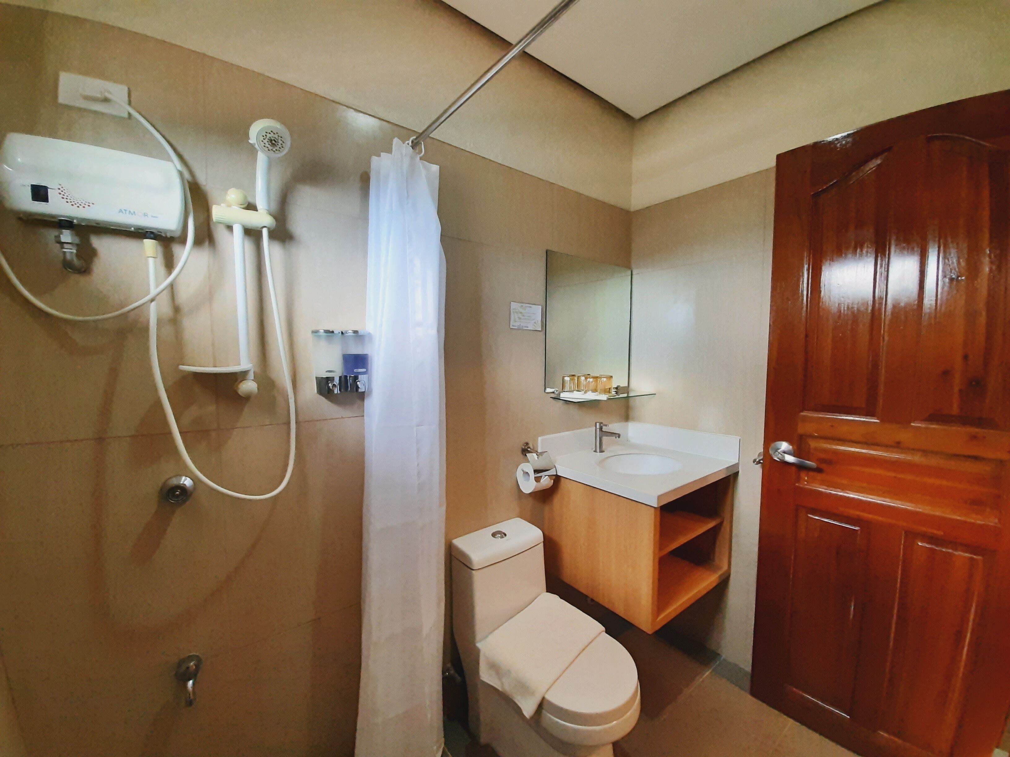deluxe room | bathroom | shower, hydromassage showerhead, towels