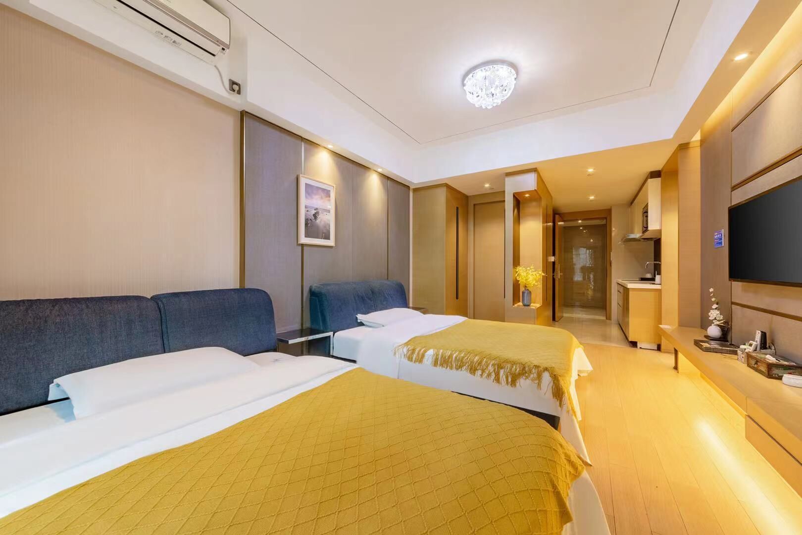 Ein Hotelzimmer mit zwei Betten, einem Fernseher, einem Schreibtisch und einem durchgegangenen Badezimmereingang.