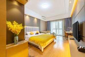 Une chambre d’hôtel moderne dotée d’un grand lit, d’un bureau, d’une télévision et offrant une vue sur la ville.