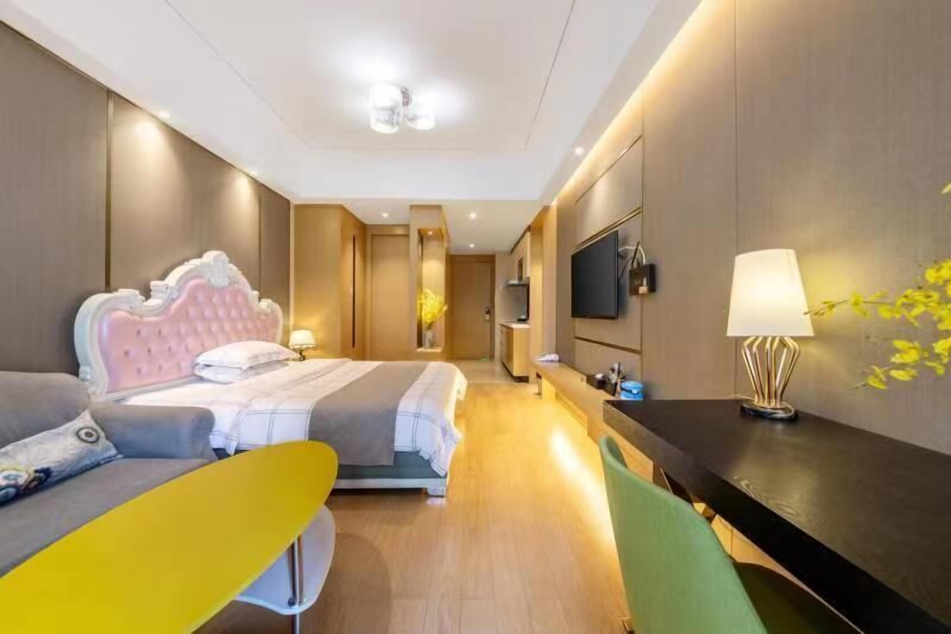 Una habitación de hotel moderna con una cama, un escritorio, una silla y un televisor.
