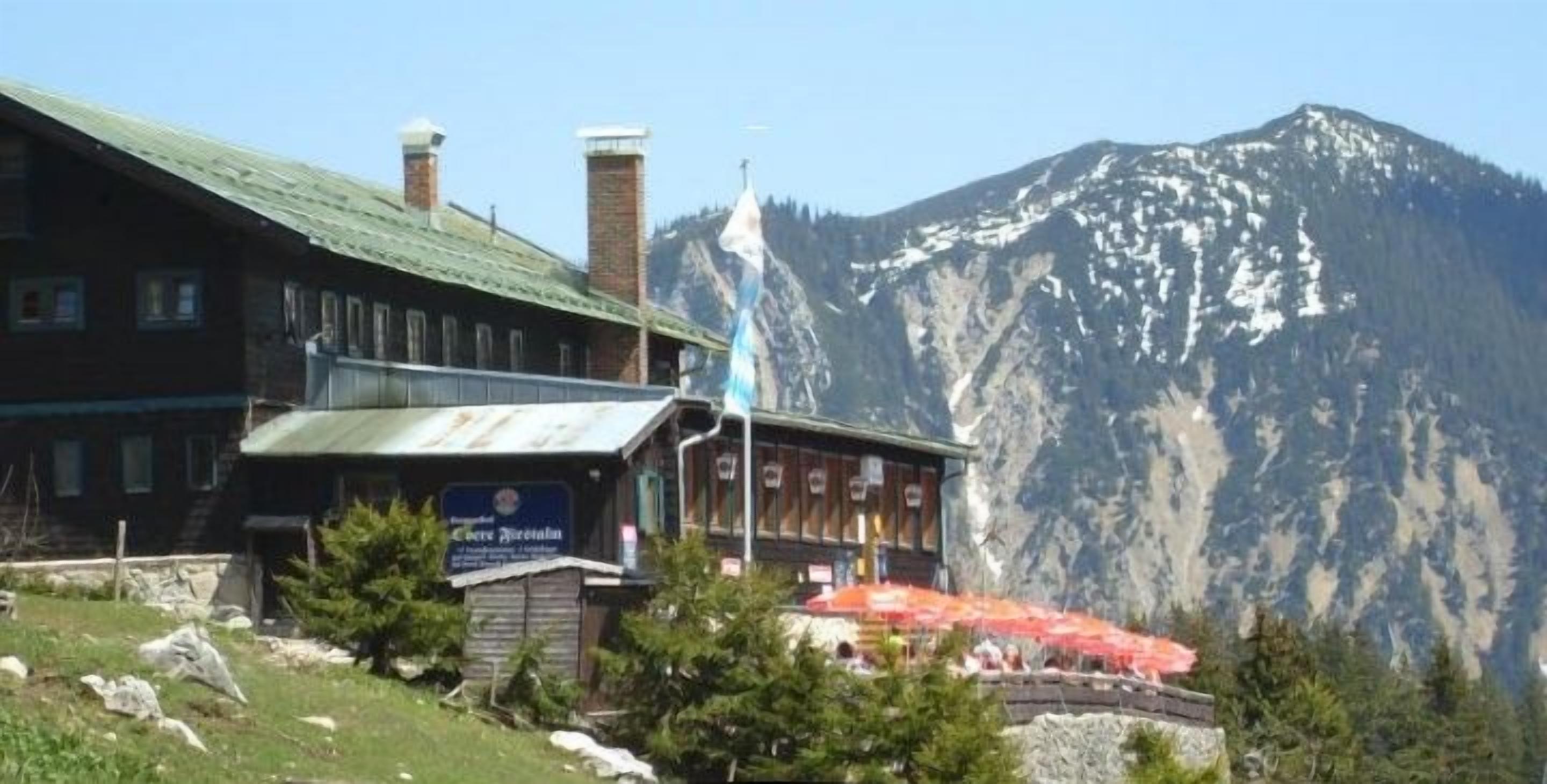 Un chalet de montagne avec un panneau indiquant un sentier de randonnée de 2,4 km.