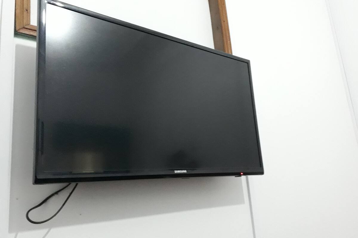 En platt-TV som är monterad på en vit vägg.