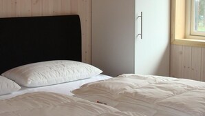 Une chambre à coucher avec un lit, une armoire et une fenêtre.