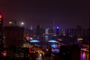 A nighttime cityscape with illuminated buildings and a bridge with festive lights. - YOYO Apartment Jinrong Branch (Guangzhou)