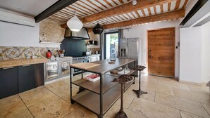 A modern kitchen with a central island, built-in appliances, and a rustic ceiling. - Luxurious home in Vedène (Vedène)