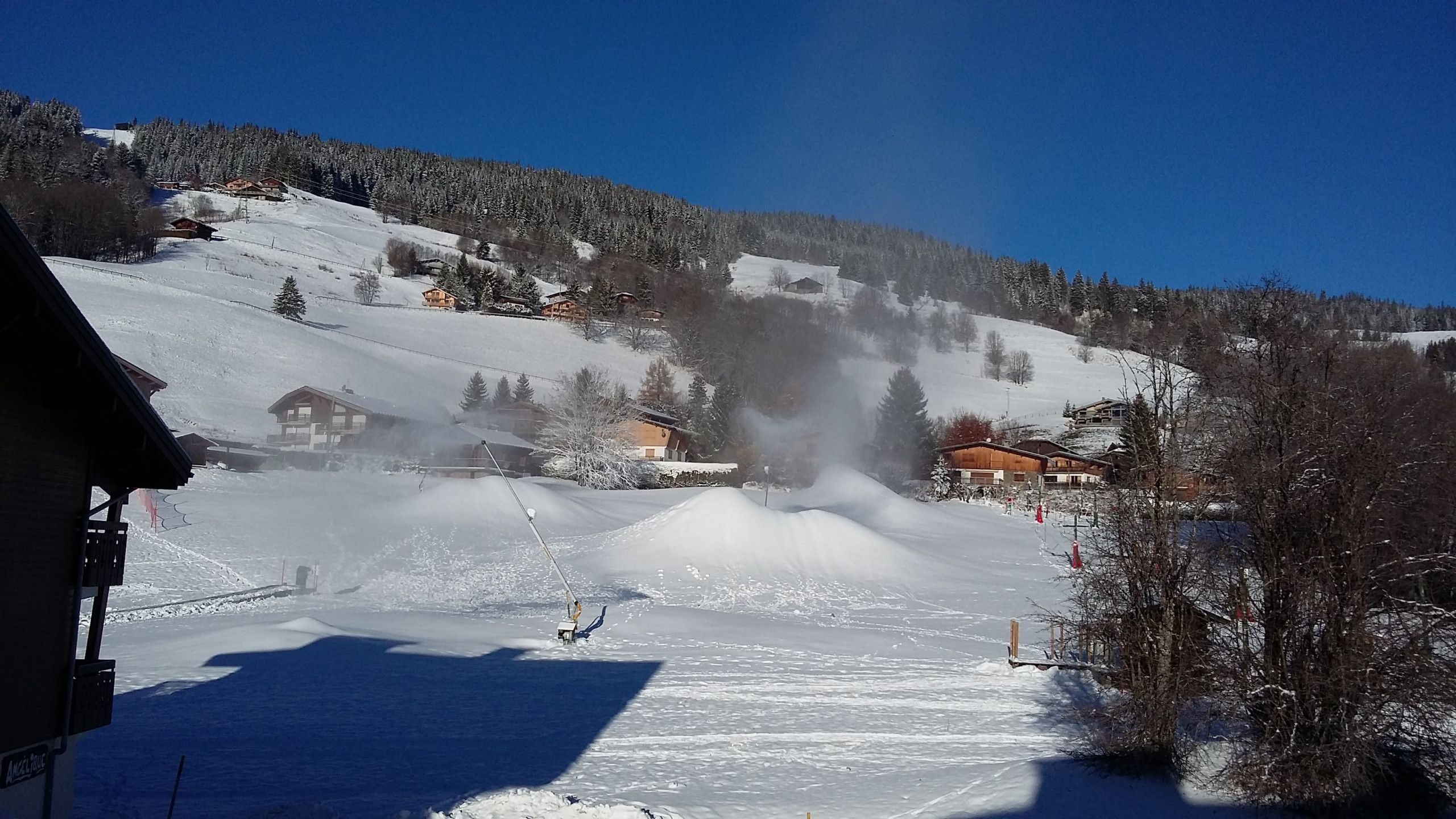 Paesaggio montuoso innevato con una seggiovia e edifici sullo sfondo.