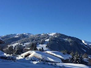 Montanha coberta de neve com um resort de esqui, incluindo edifícios e pistas.